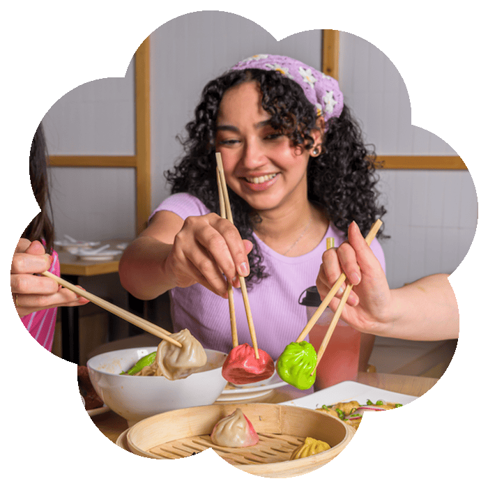 Friends enjoying colorful soup dumplings at Ugly Dumpling restaurant